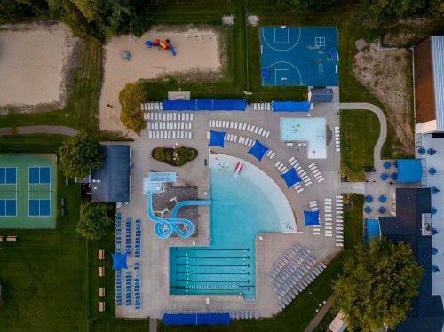 MVP Crahen, Outdoor Pool, Birds eye view of pool area with two pools, slide, and chairs.